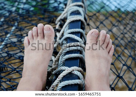 feet relaxing on vacation net seat.