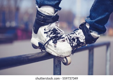 Feet Of Roller Blader Guy Grind Railing In Outdoor Street Skate Park.Close Up Of Extreme Aggressive Inline Skating Trick.Top Soul Grind On High Speed.Chrome Rail In Skatepark