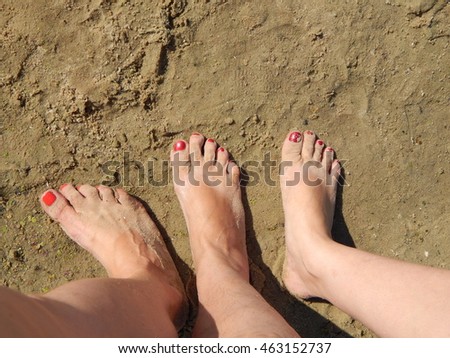 Feet in the sand three female legs
