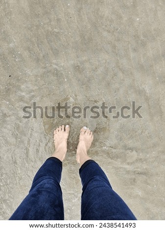 feet in the sea water jeans legs