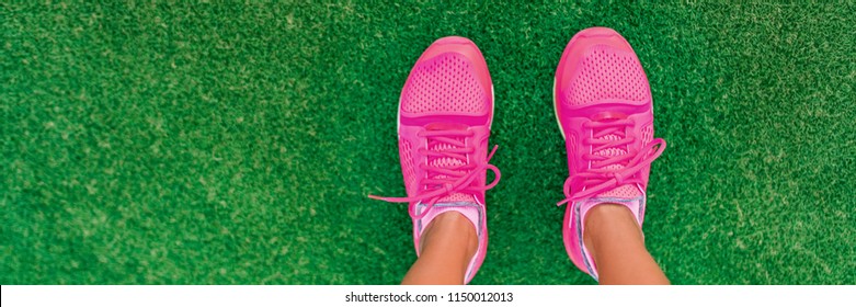 Feet Selfie Of Pink Fashion Running Shoes POV Standing On Grass Of City Park. Girl Ready To Go Jogging Outside Walking On Copy Space Banner Background.