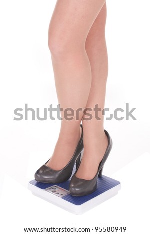 Feet in shoes on scale under the white background