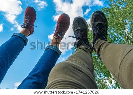 Feet in the sky. Man and woman with raised legs against the sky