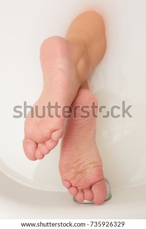 Feet soaking in spa bath with copy space