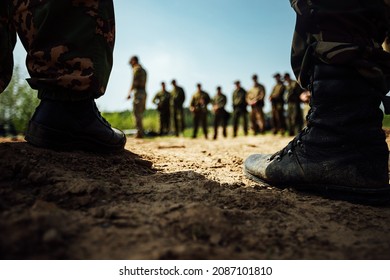 The Feet Of Soldiers In Army Boots Are Standing On The Sand. Training Ground Before A Long March