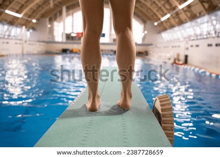 the feet of sportswoman athlete diver standing on a springboard in swimming pool Stockfoto © 