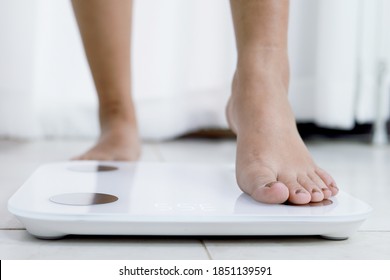 Füße auf elektronischen Waagen zur Gewichtskontrolle. Messgerät in Kilogramm für eine Diätkontrolle