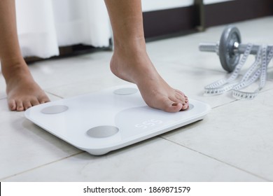 feet standing on electronic scales for weight control. Measurement instrument in kilogram for a diet control - Powered by Shutterstock