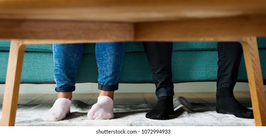 Feet sticking out under a sofa table