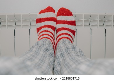 Feet In Striped Socks On The Heating Radiator At Home