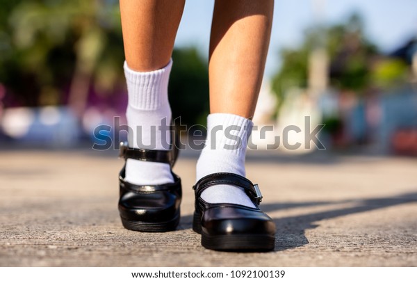 タイ人の女の子の足は 黒い学生用の靴をコンクリートに履いている コンセプトを学校に戻す の写真素材 今すぐ編集