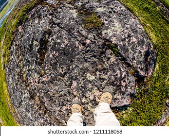 Feet Of Tourist In Sport Hiking Shoes Walking On The Tundra. Concept For Travelling And Adventure. Fish Eye Lens Image