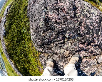 Feet Of Tourist In Sport Hiking Shoes Walking On The Tundra. Concept For Travelling And Adventure. Fish Eye Lens Image