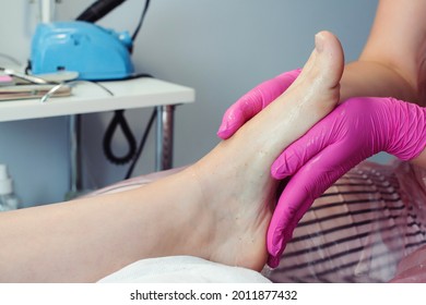Feet treatment. Beauty treatment for legs. Pedicure master massaging feet with scrub. Professional pedicure in the beauty salon. Woman relaxing at salon, caring about nails.