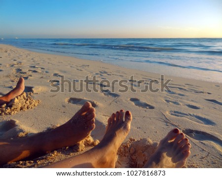 feet of two lovers on the beach near the water