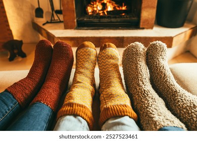 Feet view of happy family wearing warm socks in front of fireplace - Winter, love and cozy lifestyle concept - Focus on center socks - Powered by Shutterstock