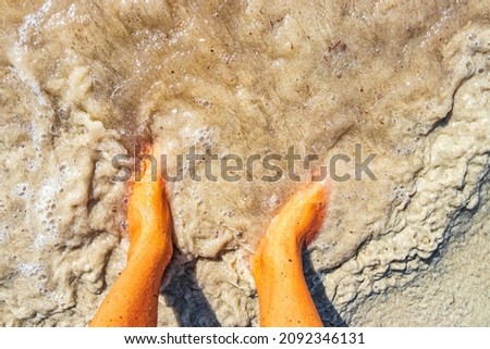 Feet in the water and sand of the tropical mexican beach of Playa 88 and Punta Esmeralda in Playa del Carmen Mexico.