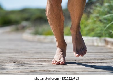 Feet Of White Man Driving Forward While Running Barefoot With Unfocused Background.