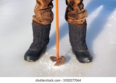 Feet In Winter Boots And Ice Drill