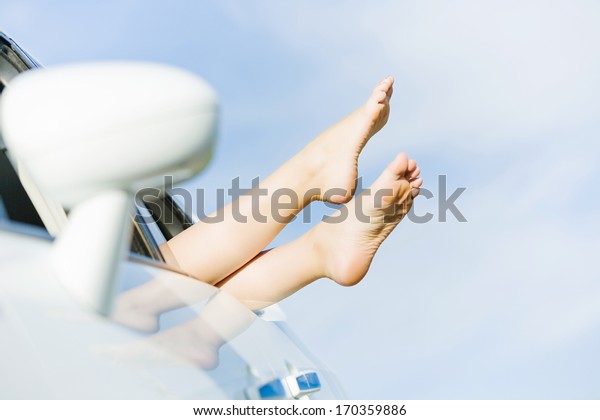 Feet of woman leaned\
out of car window
