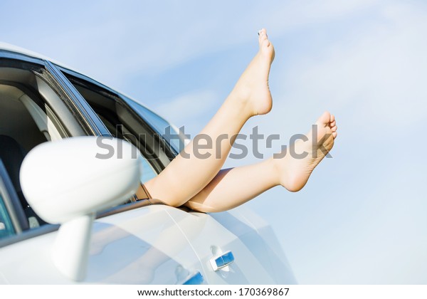 Feet of woman leaned\
out of car window