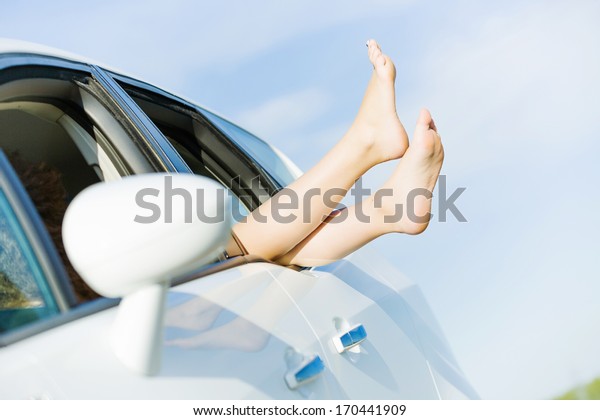 Feet of woman leaned
out of car window