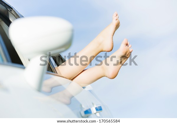 Feet of woman leaned
out of car window