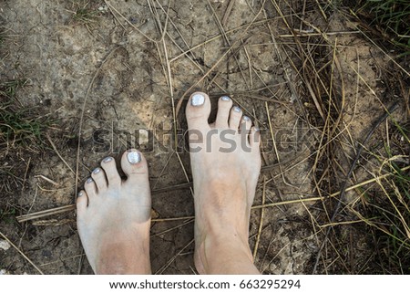 feet of a woman with a pedicure on the ground
