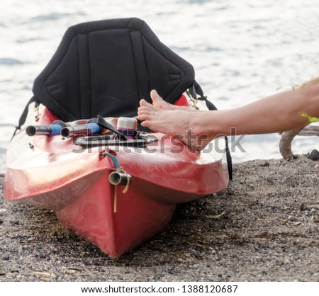 Feet of a woman resting on a canoe at Anaehoomalu beach, Big Island