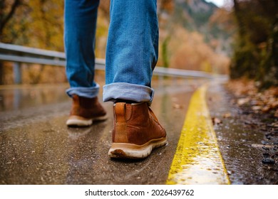 Feet Of A Woman Walking Along Asphalt Road In Autumn Forest In The Rain. Pair Of Shoe On Slippery Road In The Fall. Abstract Empty Blank Of The Autumn Weather