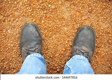 Feet In Work Boots On Gravel