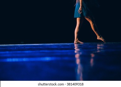The feet of a young contemporary dancer on blue floor - Shutterstock ID 381409318