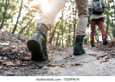 Feet Of Young Couple Hiking In The Woods