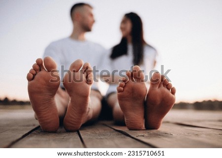 feet of a young couple on the background of the river