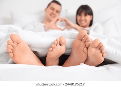 Feet of young loving couple lying in bedroom, closeup - Powered by Shutterstock