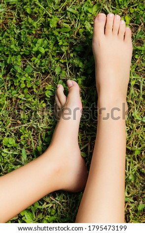 Feet of young woman resting on the grass in the park after a day's work.