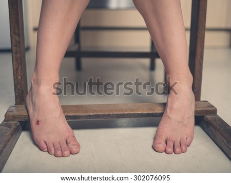 The feet of a young woman with a scab on one of them