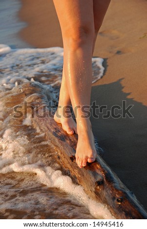 Feet of a young woman walking on the log