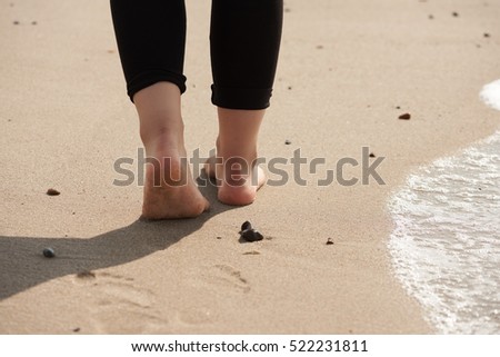 Feet of a young woman walking on the beach north sea coast