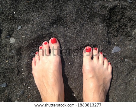 Feets on black summer beach