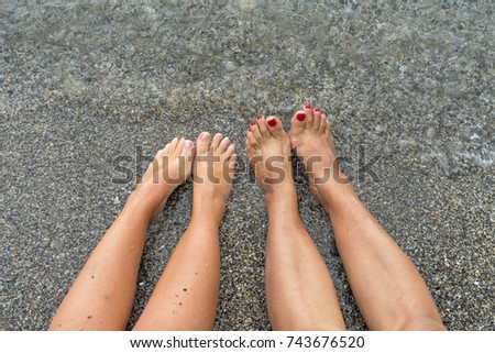 Feets relaxing at the beach in the water.