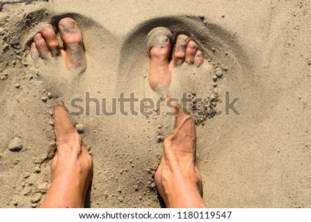 feets in the sand on a beach
