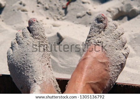 Feets with sand on beach