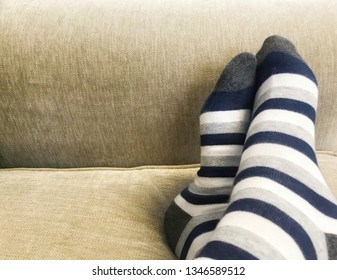 Feets with striped feets on sofa - Shutterstock ID 1346589512