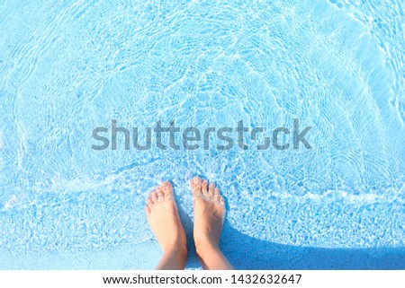 feets in swimming pool with blue water
