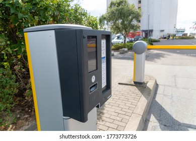 FEHMARN, GERMANY - Sep 05, 2019: A Yellow Barrier With Associated Parking Ticket Machine For Opening To A Private Parking Lot Of A Hotel.