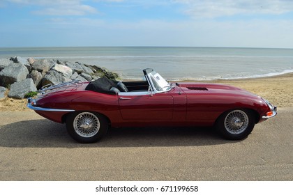 FELIXSTOWE, SUFFOLK, ENGLAND -  MAY 07, 2017: Classic Red Jaguar  E  Type Convertible Motor Car Parked on Seafront Promenade.