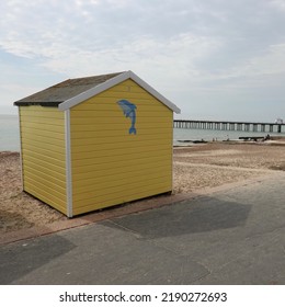 Felixstowe, Suffolk, UK - 15 August 2022 : Yellow Beach Hut Beside The Promenade.