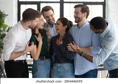 Fellowship. Happy Diverse Young Friends Multiethnic Coworkers Business Partners Students Hugging Talking Laughing In Office University Hallway Greeting Indian Female Mate With Achievement Luck Success