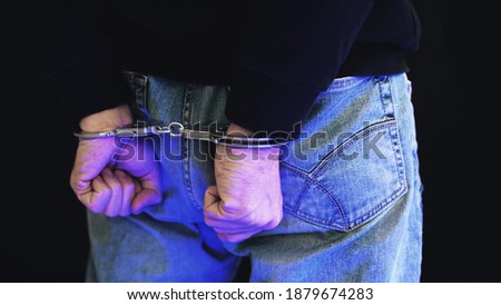 Felon in handcuffs with police strobe flashes
